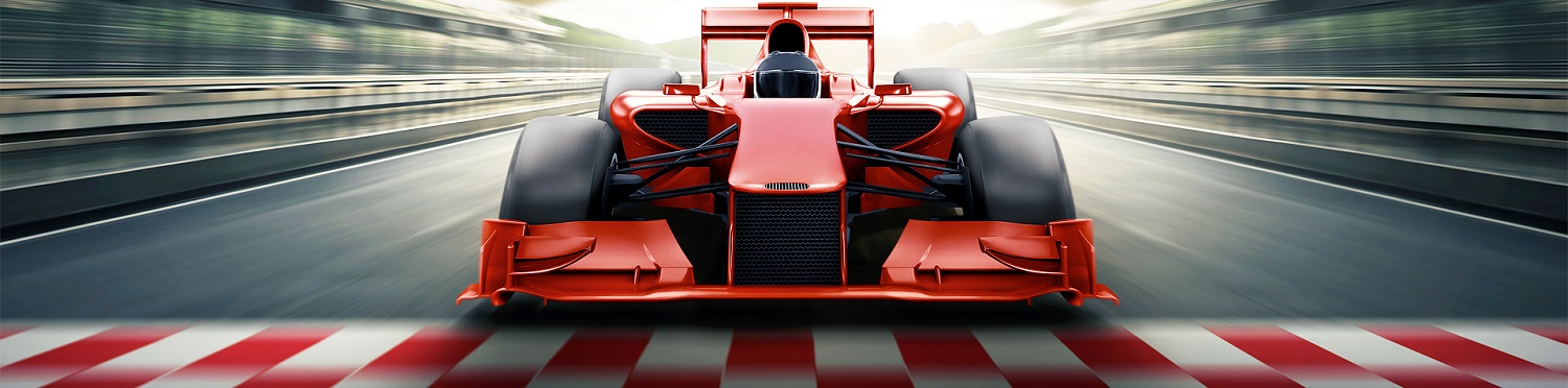 Formel1 Auto Frontal blickt ein Formel1 Rennwagen zur Kamera. Unter dem Rennwagen rot-weiß markierte Ziellinie. Der Rennwagen rast mit hoher geschwindigkeit. Alles außer dem Auto ist verschwommen