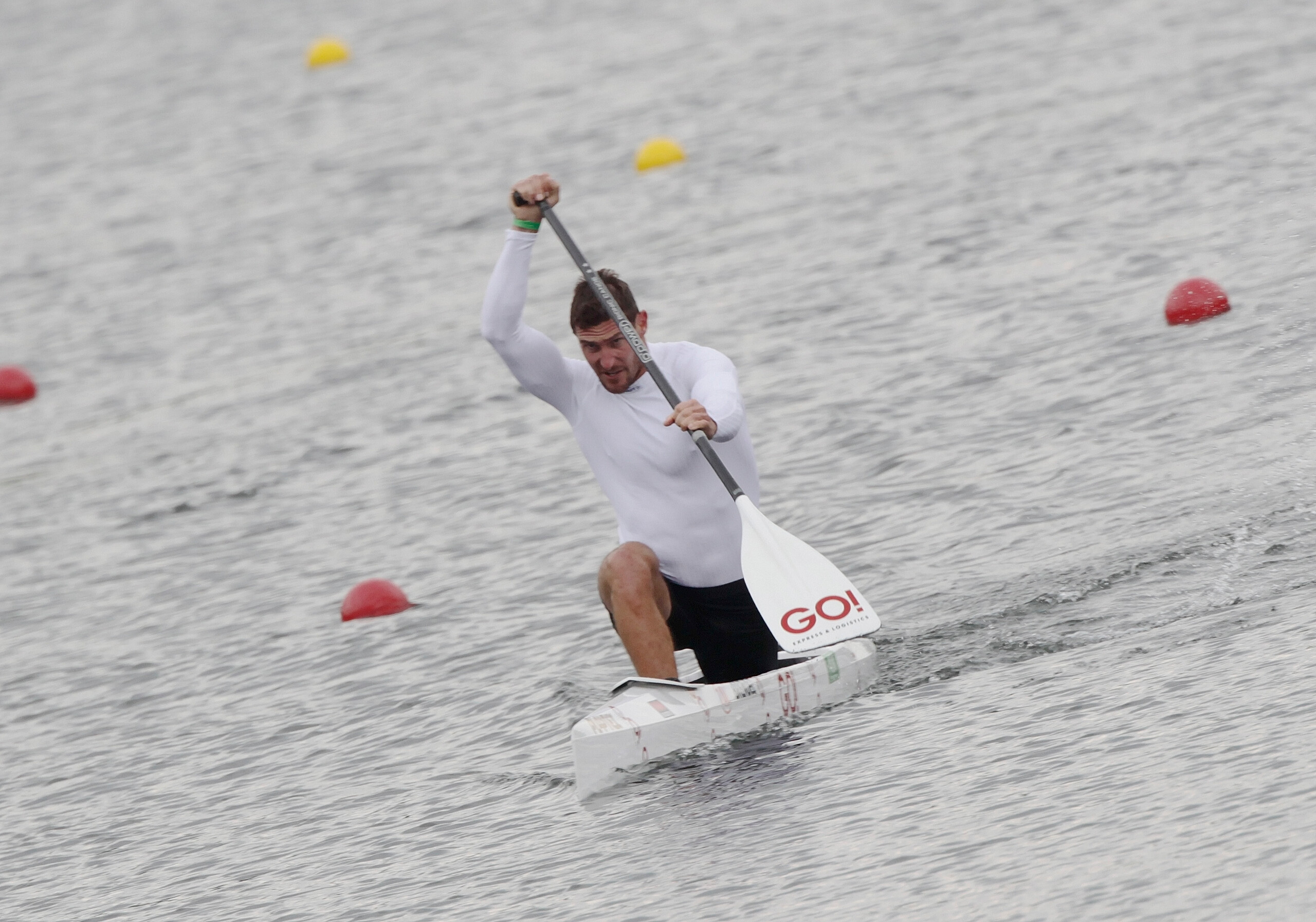 Sebastian Brendel paddelt auf seinem Kanu im Wasser. Auf dem Paddel ist das GO! Logo zu sehen