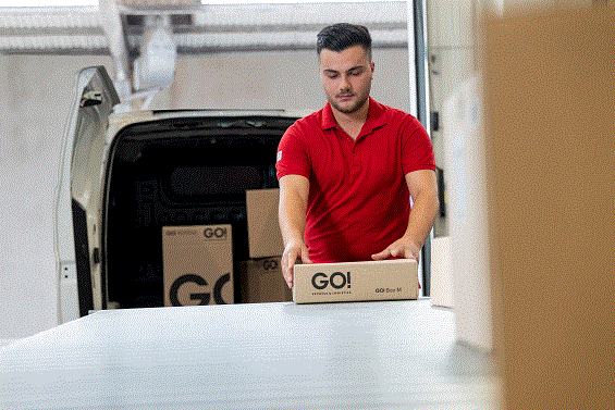 GO! Kurier entlädt Pakete aus offenem GO! Transporter