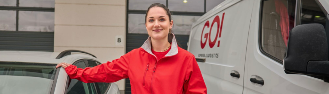 Kurýrka GO! Express & Logistics u doručovacího auta