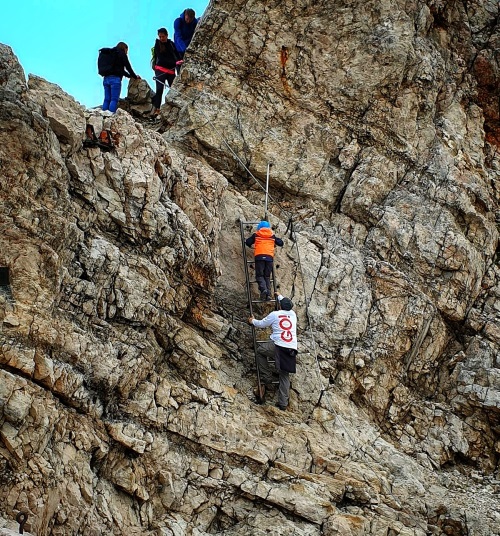 Eine Nahaufnahme von einem Abschnitt der Zugspitze. Bergsteiger kletter auf den Gipfel. Einer der Bergsteiger trägt eine Jacke mit GO! Logo