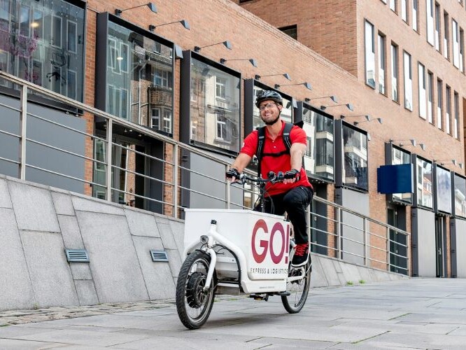 GO! Kurierfahrer liefert Pakete mit seinem Lastenfahrrad.