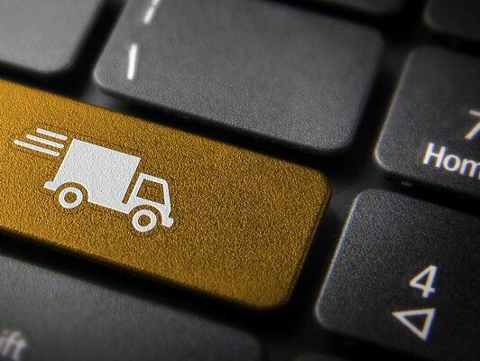 Computertastatur mit einer gelben Taste und weißem Motiv eines Transporters